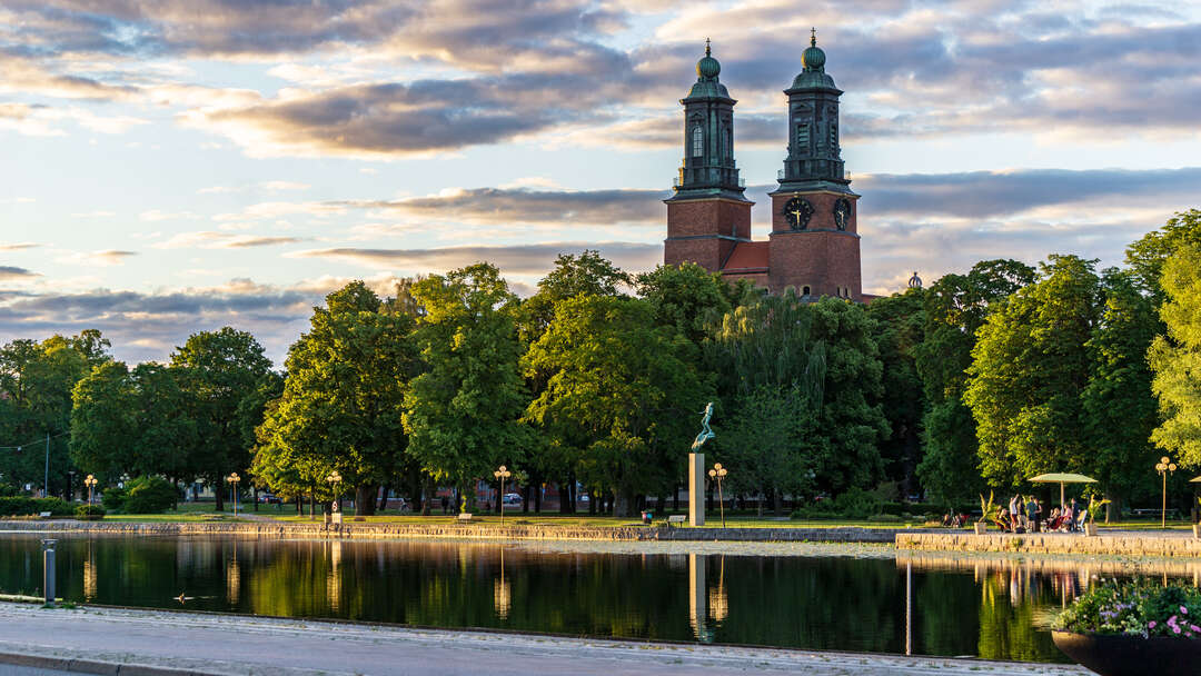 Vy av Eskilstuna med vatten i förgrunden och kyrka i bakgrunden